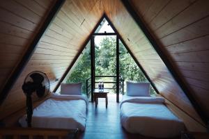 KhawāsaLA SELVA Resort, Pench National Park的带大窗户的客房内的两张床