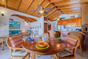 圣佩德罗Coral Bay Villas的厨房以及带木桌和椅子的用餐室。