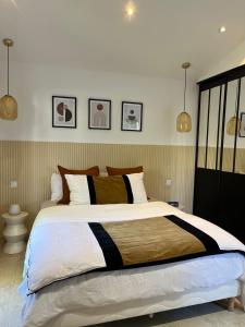 马赛Suite La Farigoulette的卧室内的一张大床,配有两个吊灯