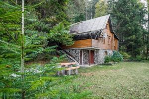 LučivnáOld Fashioned Cottage in Lopusna dolina near High Tatras的前面设有长凳的木屋