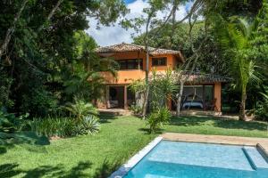 托兰克索Casa Laranjeiras, Rio da Barra beach, Trancoso的别墅前设有游泳池