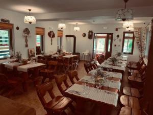 阿尔杰什河畔库尔泰亚Dorul Pescarului的餐厅设有长桌子和椅子以及灯