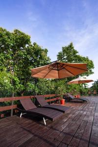 KhawāsaLA SELVA Resort, Pench National Park的庭院配有遮阳伞和桌椅。