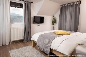 莫伊西德约斯Casa269b - Cozy house with scandinavian design的一间卧室设有一张床、一台电视和一个窗口。