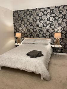 KentStylish & Spacious 2 Storey, 3 Bed Apartment的一间卧室配有一张床和两张带台灯的桌子。