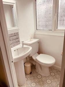 KentStylish & Spacious 2 Storey, 3 Bed Apartment的白色的浴室设有卫生间和水槽。