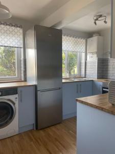 KentStylish & Spacious 2 Storey, 3 Bed Apartment的厨房配有冰箱和洗衣机。