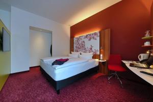 莱茵河畔因格尔海姆英格尔海姆IBB酒店的一间卧室配有一张床和一张带电脑的书桌