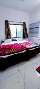 菩提伽耶Nilam Guest House的窗户客房内的一张大床
