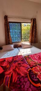 菩提伽耶Nilam Guest House的一间卧室设有两张床和窗户。