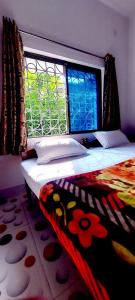 菩提伽耶Nilam Guest House的窗户和地毯的房间里一张床位