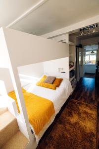 福克斯通Annexe with Sea View, Private Entrance & Parking - FOLKESTONE的卧室配有一张带黄色毯子的大型白色床