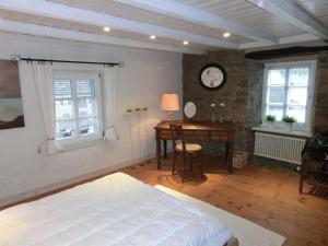 布兰肯海姆Haus-Hoeppches的卧室配有一张床、一张书桌和窗户。