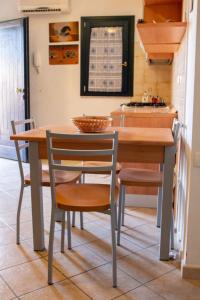 瓦雷多利亚Valledoria 2 Apartments的厨房配有木桌、椅子和柜台