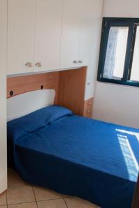 瓦雷多利亚Valledoria 2 Apartments的一间卧室设有蓝色的床和窗户。