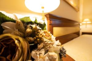 维博瓦伦蒂亚韦基亚威宝餐厅酒店的在酒店房间床上放一束鲜花