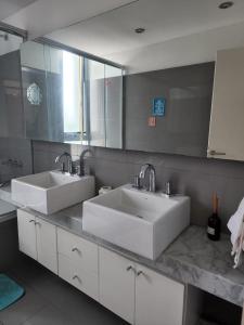 布宜诺斯艾利斯Apartamento Av kennedy y Cerviño a metros embajada EEUU的一间带两个盥洗盆和大镜子的浴室