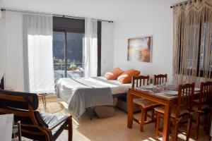 埃尔塔特Apartament Mufló Apartamento encantador con vistas espectaculares a la X de Grandvalira的一间卧室配有一张床和一张桌子及椅子