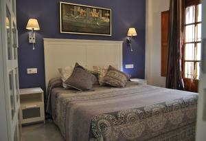 科尔多瓦楼梯露台公寓的一间卧室配有一张紫色墙壁的床