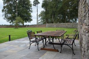 恩尼斯基林Rectory Cottage. Close to Enniskillen and lakes.的一张木桌和椅子,后方是公园