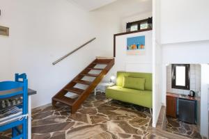 基萨莫斯Captain's Beach Apartments的客厅设有绿色沙发和楼梯。