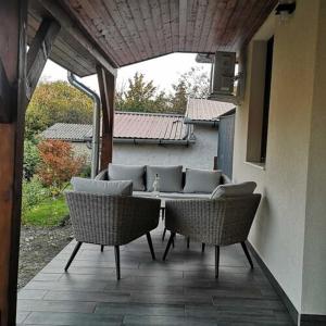 锡盖特堡Kis Ház Apartman的户外庭院配有两把椅子和一张沙发