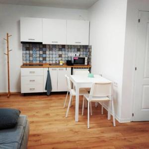 锡盖特堡Kis Ház Apartman的厨房配有白色的桌子和白色的椅子