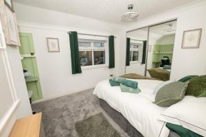 布里德灵顿EmmaDale Central Bridlington sleeps 7-8的一间卧室配有两张床和镜子