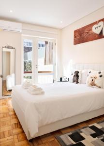 波尔图Refugio的白色的卧室设有一张白色大床和一个窗户。