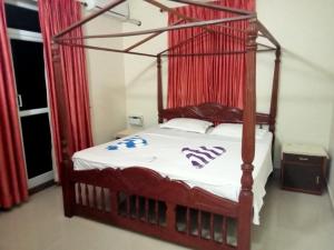 瓦尔恰Asian Paradise comfort的一间卧室配有一张带红色窗帘的四柱床