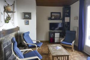勒·雷约尔·卡纳德尔·苏尔Villa l'Escapade的客厅配有蓝色椅子和壁炉