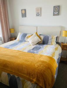 布莱奇利Rooftops Apartment的一间卧室配有一张黄色和蓝色毯子的床