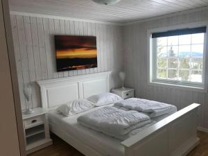 斯朱森Stor familiehytte på Småsætra, Sjusjøen的一间白色卧室,配有两张床和窗户
