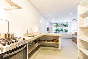 马利西亚斯Anoa Maresias Studios的厨房配有水槽和炉灶 顶部烤箱
