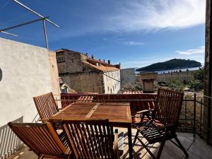 杜布罗夫尼克Beautifully Restored 400-year Old House with Stunning Sea Views from the Terrace的阳台上的木桌和椅子