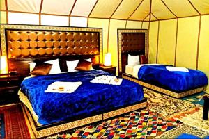 梅尔祖卡Ahlam Luxury Camp的一间帐篷内带两张床的卧室