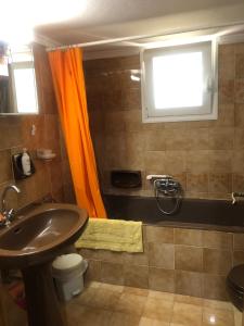 KalavárdaLemon tree's house的浴室设有橙色窗帘和水槽
