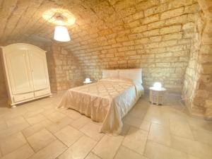 巴里Dimora Pietra Antica的卧室配有一张石墙床