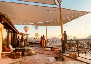格雷梅Osmanli Cappadocia Hotel的一群人站在带热气球的阳台上