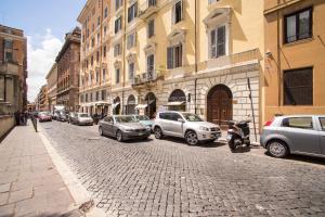 罗马罗马市中心马赛克酒店的一条鹅卵石街道,有停车的汽车和建筑