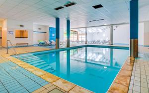 莱代塞尔Fleurs des Alpes的大楼内一个蓝色的大型游泳池