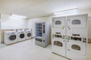 拉雷多Baymont by Wyndham Laredo的洗衣房配有4台机器和白色墙壁