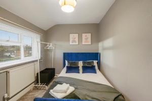 斯特鲁德Cosy home in Rochester, sleeps 6的一间卧室配有蓝色的床和蓝色床头板