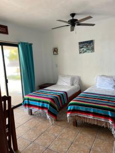 艾克斯卡拉克CASA PARAÍSO的一间卧室配有两张床和吊扇
