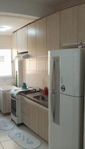 库亚巴Apartamento inteiro próximo à Miguel Sutil的厨房配有白色冰箱和炉灶。