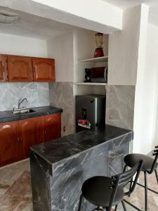 科利马Bonito y Céntrico Alojamiento的厨房配有带2把椅子和水槽的台面