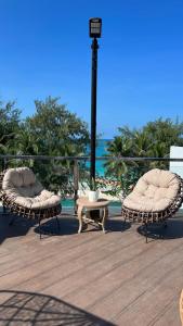 长滩岛The Paragon Boracay Suites的海滩甲板上的两把椅子和一张桌子