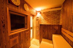 挂川市多美迎EXPRESS掛川酒店的小房间配有电视和墙上的时钟
