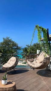 长滩岛The Paragon Boracay Suites的两把藤椅坐在海滩附近的庭院