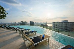 芭堤雅市中心Somerset Pattaya - SHA Plus的一座带椅子的建筑屋顶上的游泳池